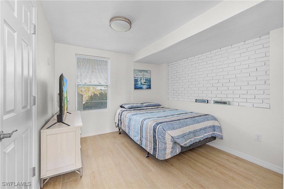 3128 Stringfellow Road St. James City, FL 33956 - Photo 36 of 50 a bedroom with a bed a mirror and next to a window