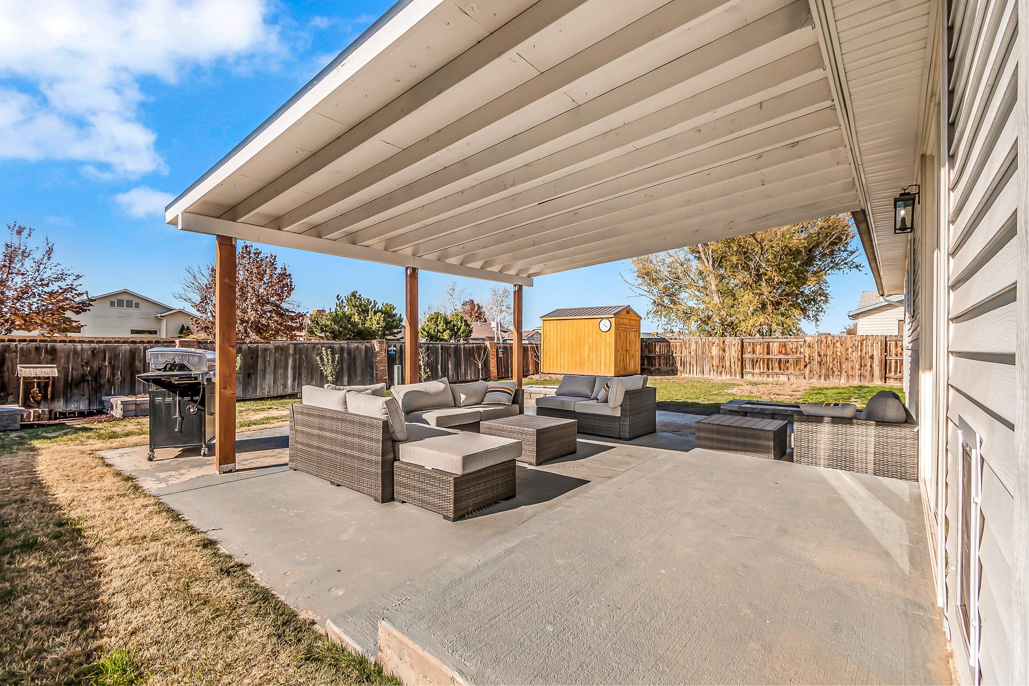 505 North Oak Street Fruita, CO 81521 - Photo 18 of 21 a view of a patio with couches and table and chairs with wooden floor and fence