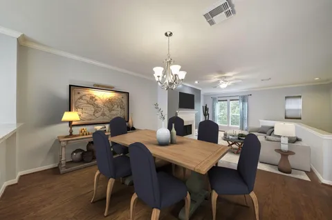 a view of a dining room with furniture a chandelier and wooden floor