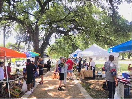 a group of people sitting in front of retail shops