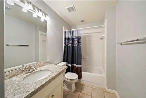 a bathroom with a granite countertop sink toilet and shower