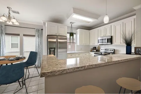 a kitchen with stainless steel appliances granite countertop a sink refrigerator and cabinets