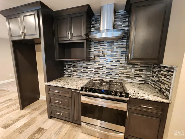 a kitchen with granite countertop stainless steel appliances and wooden cabinets