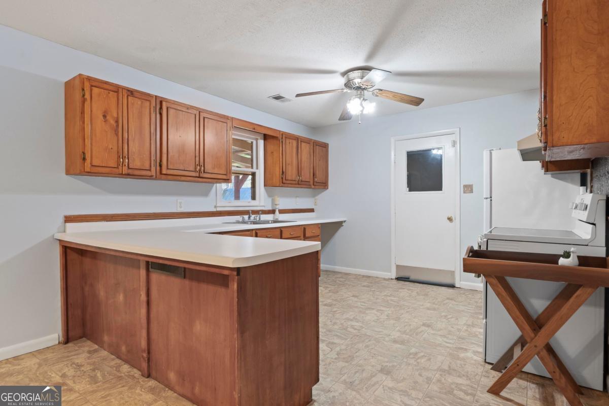 3021 Penfield Road Greensboro, GA 30642 - Photo 19 of 50 a kitchen with stainless steel appliances granite countertop a sink stove and a refrigerator