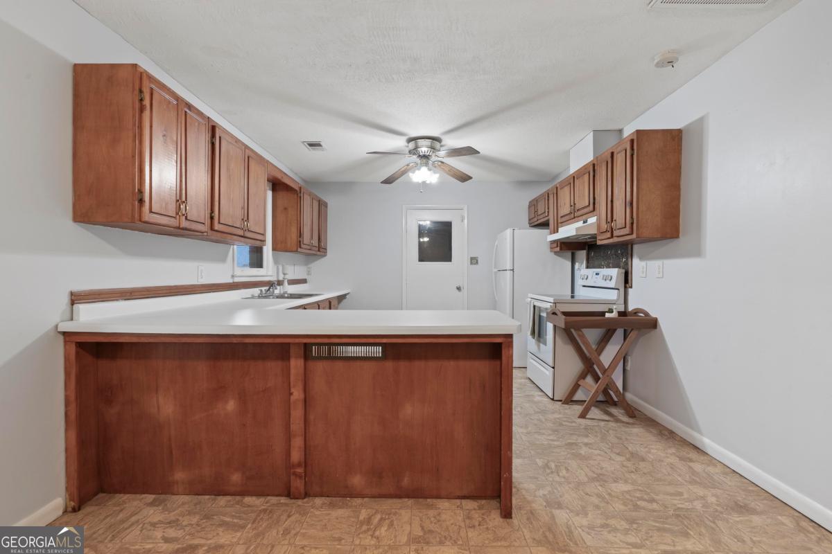 3021 Penfield Road Greensboro, GA 30642 - Photo 20 of 50 a kitchen with a sink a stove and a microwave oven