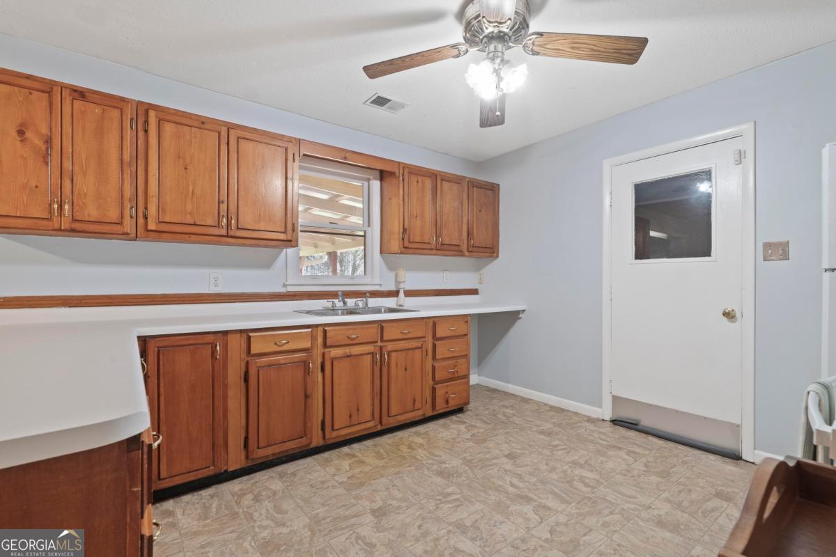 3021 Penfield Road Greensboro, GA 30642 - Photo 21 of 50 a kitchen with granite countertop a sink cabinets stainless steel appliances and a counter space