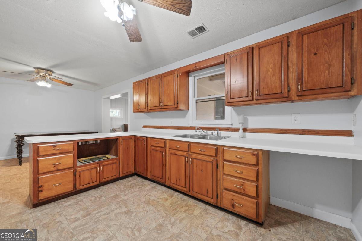 3021 Penfield Road Greensboro, GA 30642 - Photo 23 of 50 a kitchen with wooden cabinets and sink
