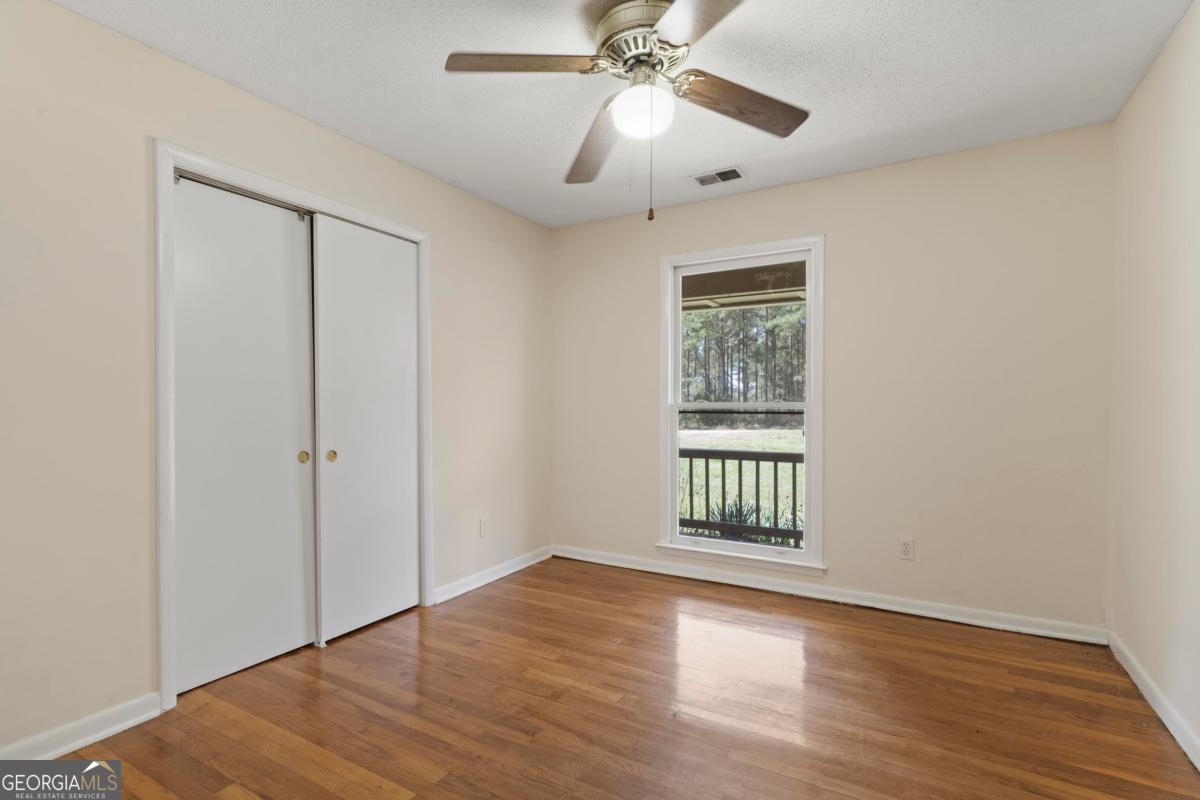 3021 Penfield Road Greensboro, GA 30642 - Photo 30 of 50 a view of an empty room with wooden floor and a window