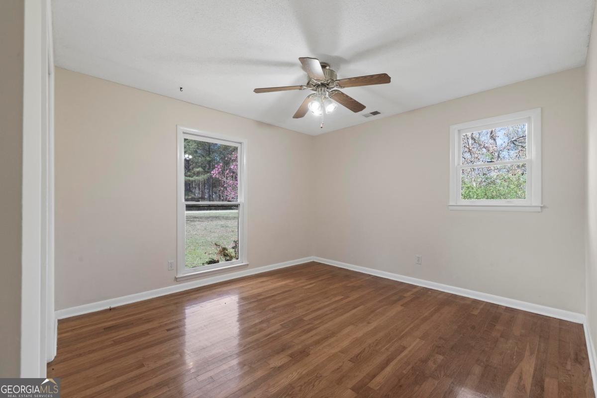 3021 Penfield Road Greensboro, GA 30642 - Photo 32 of 50 a view of an empty room with wooden floor and a window