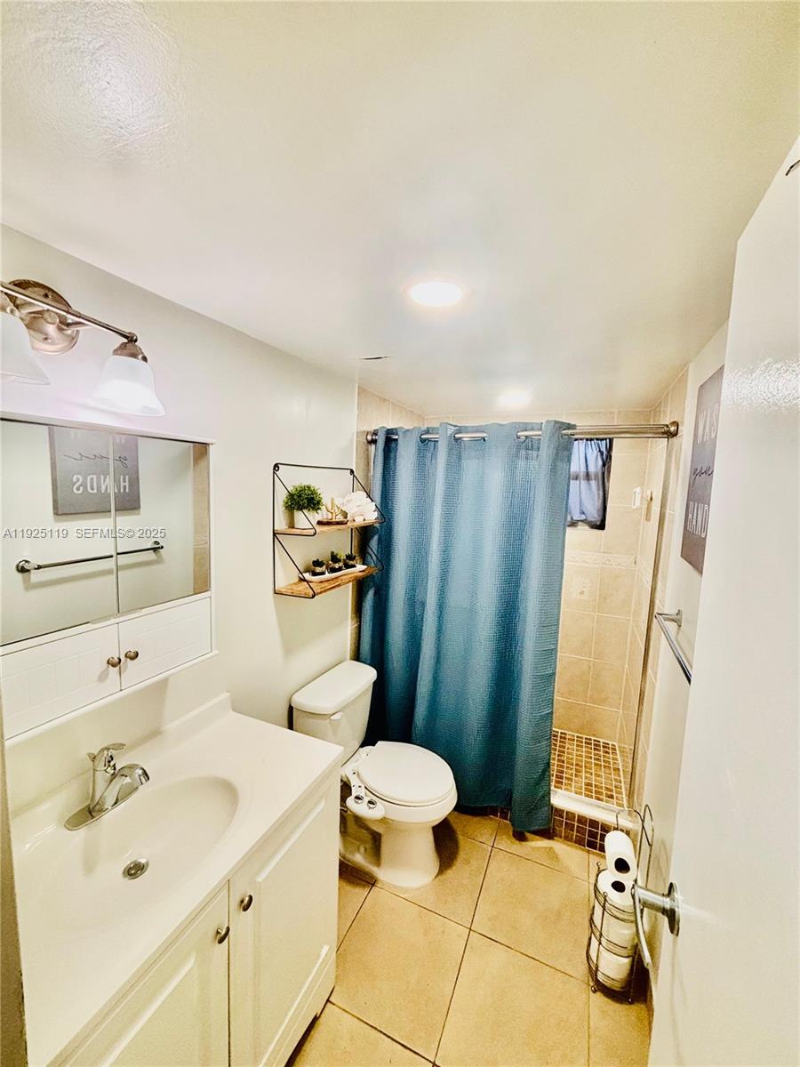 8350 Sands Point Boulevard, Unit E104 Tamarac, FL 33321 - Photo 2 of 13 a bathroom with a sink a toilet and shower