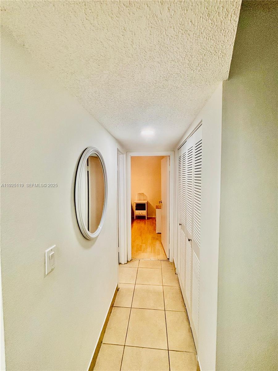 8350 Sands Point Boulevard, Unit E104 Tamarac, FL 33321 - Photo 9 of 13 a view of a hallway with painted walls