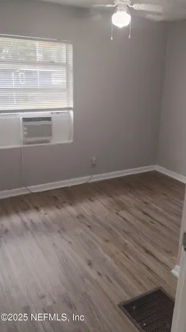 a view of empty room with wooden floor