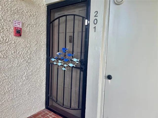 a vase with flowers sitting on a floor in front of a door