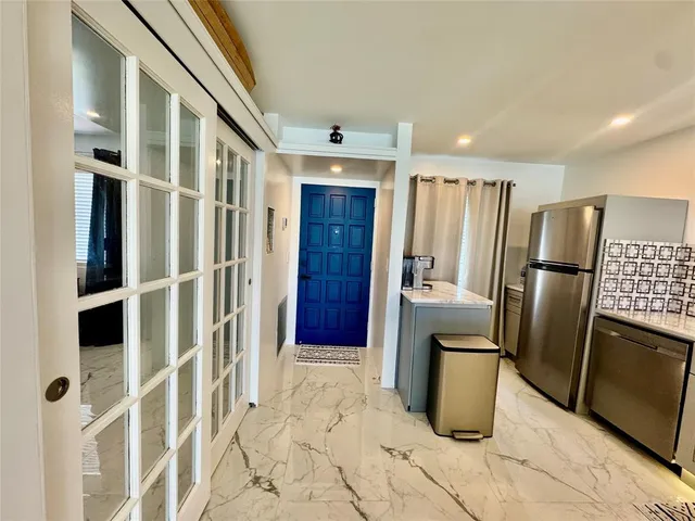a view of a refrigerator in kitchen and utility room