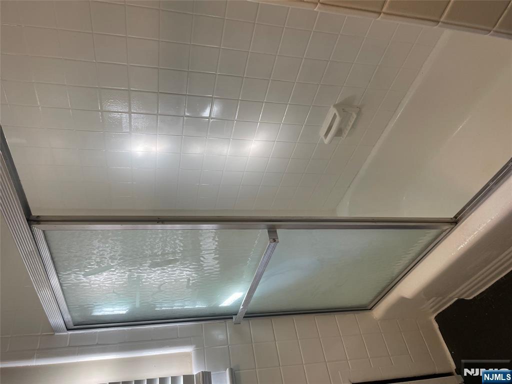 113 Hawthorne Avenue Hawthorne, NJ 07506 - Photo 12 of 19 a bathroom with a glass shower door