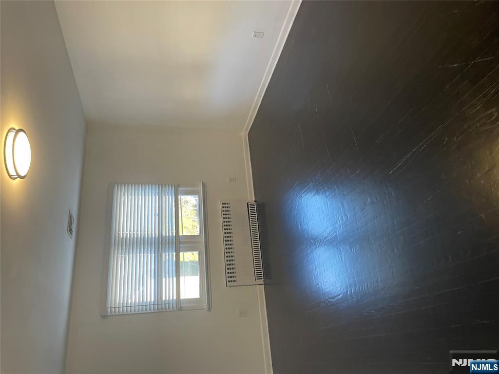 113 Hawthorne Avenue Hawthorne, NJ 07506 - Photo 4 of 19 a view of an empty room with wooden floor and a window