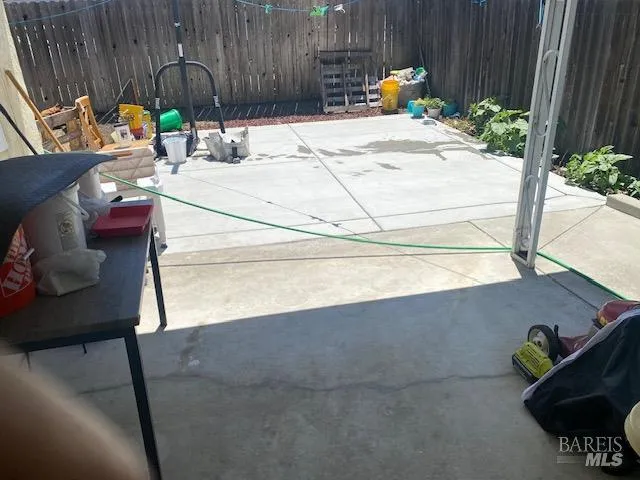 a sink sitting in a backyard with a chair and table