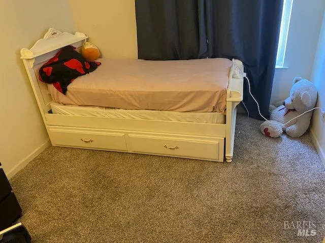 a bed sitting in a bedroom next to a window