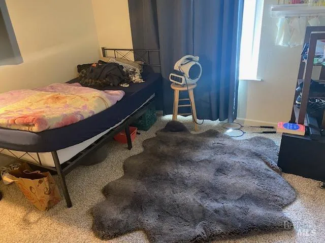 a bed sitting in a bedroom next to a window