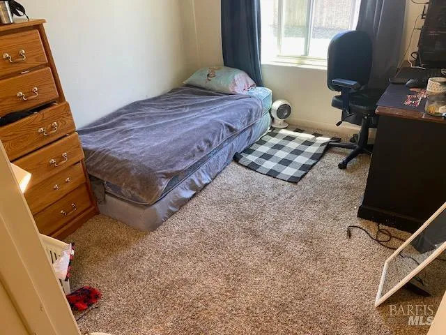 a bedroom with a bed and a flat tv screen on the dresser
