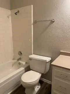 a white toilet sitting next to a bath tub