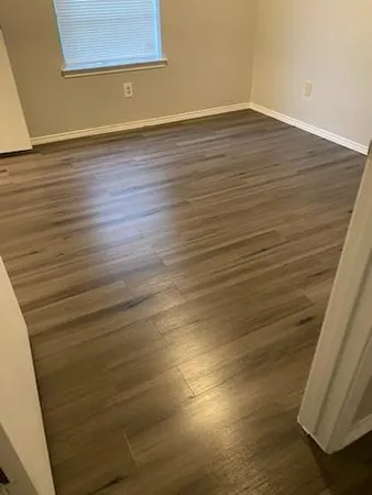 a view of an empty room with wooden floor