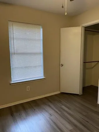 a view of a room with wooden floor and a refrigerator