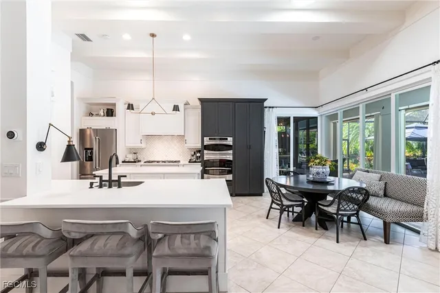 a kitchen with kitchen island a dining table and chairs