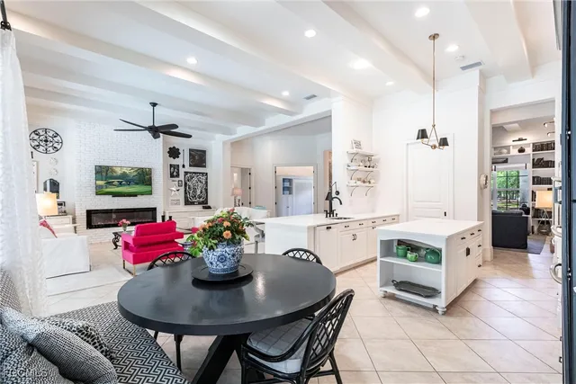 a kitchen with stainless steel appliances kitchen island granite countertop a dining table chairs and stove