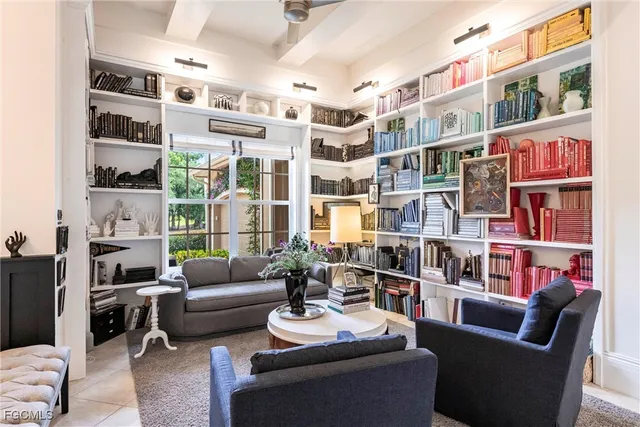 a living room with furniture a bookshelf and a large window
