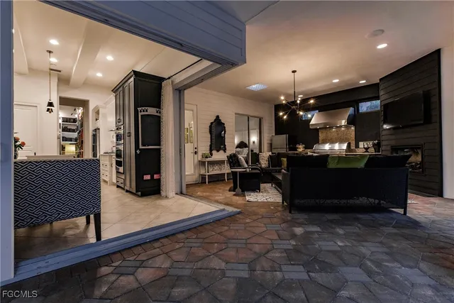 a living room with furniture a flat screen tv and kitchen view