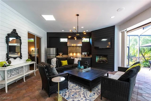 a living room with furniture a fireplace and a chandelier