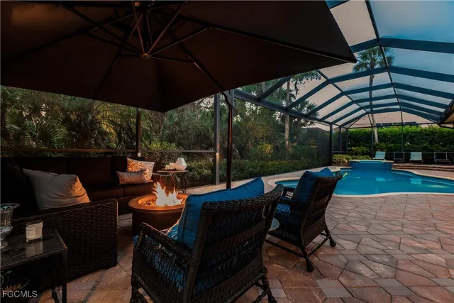 a view of a patio with table and chairs under an umbrella