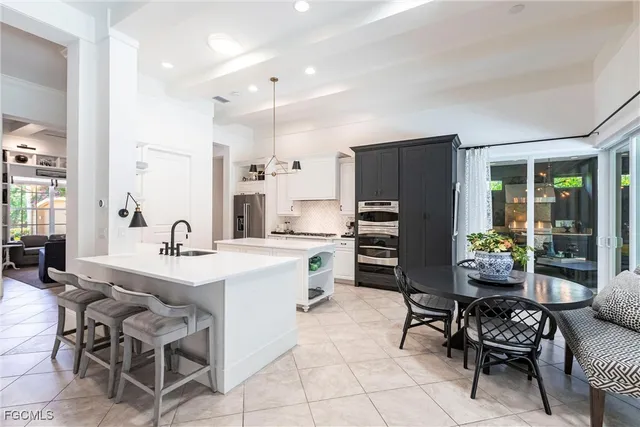 a kitchen with a dining table chairs and refrigerator