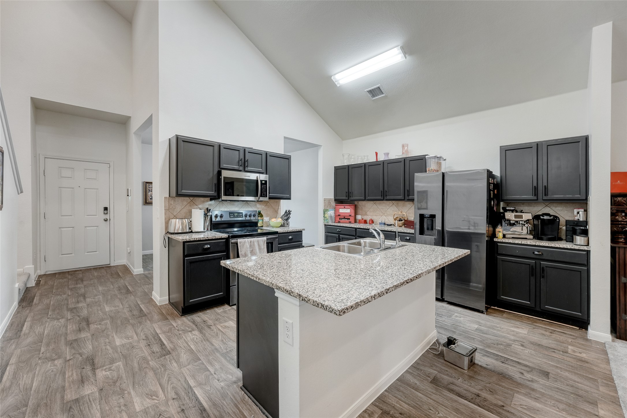 15105 Shell Bark Cove Austin, TX 78724 - Photo 5 of 30 Culinary aspirations come alive in this kitchen, featuring an inviting island with a double sink and vaulted ceilings.