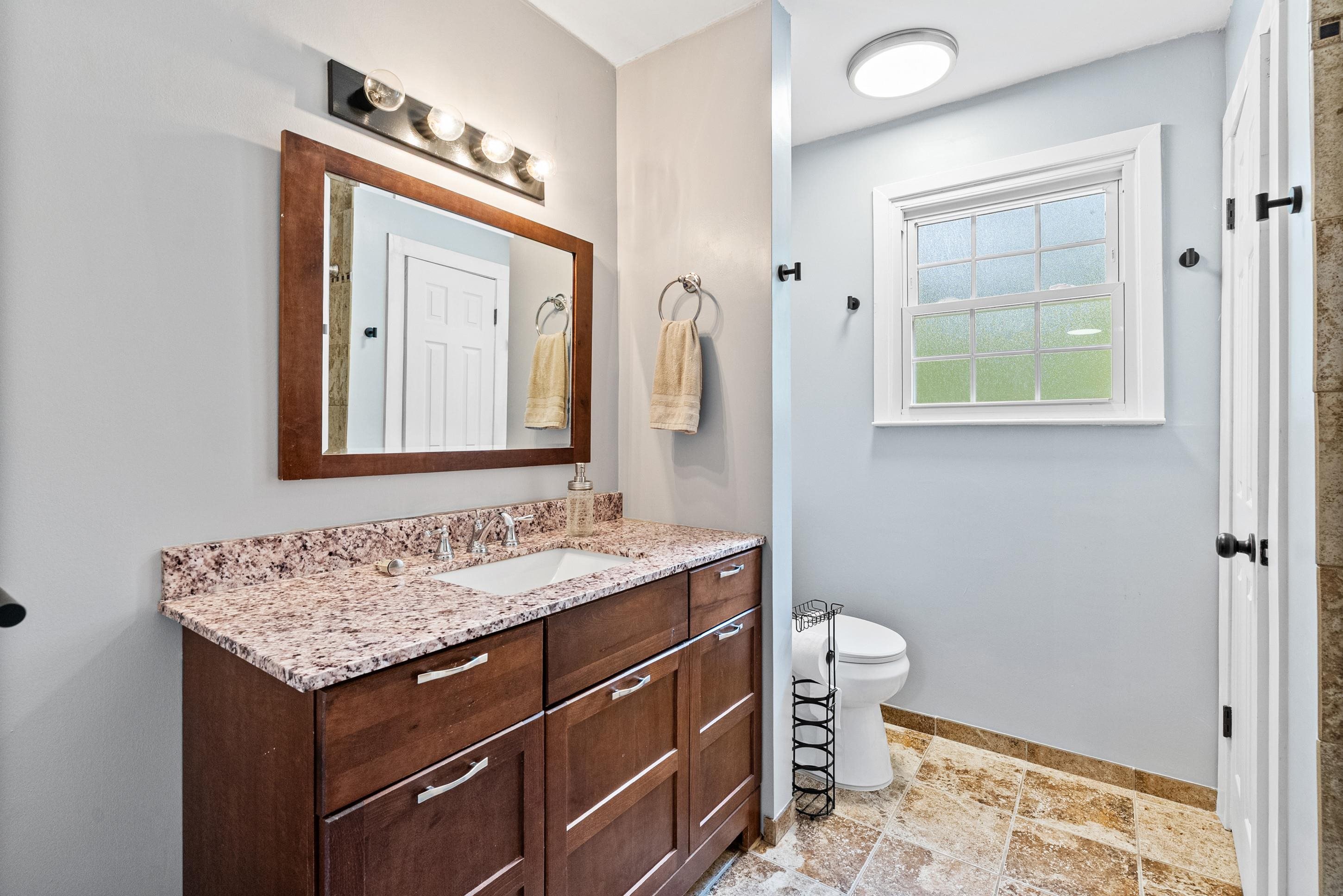 779 Strickland Road Coldwater, MS 38618 - Photo 24 of 40 Vanity with a rectangular undermount sink, granite countertop, wood-finish cabinetry, and framed mirror
