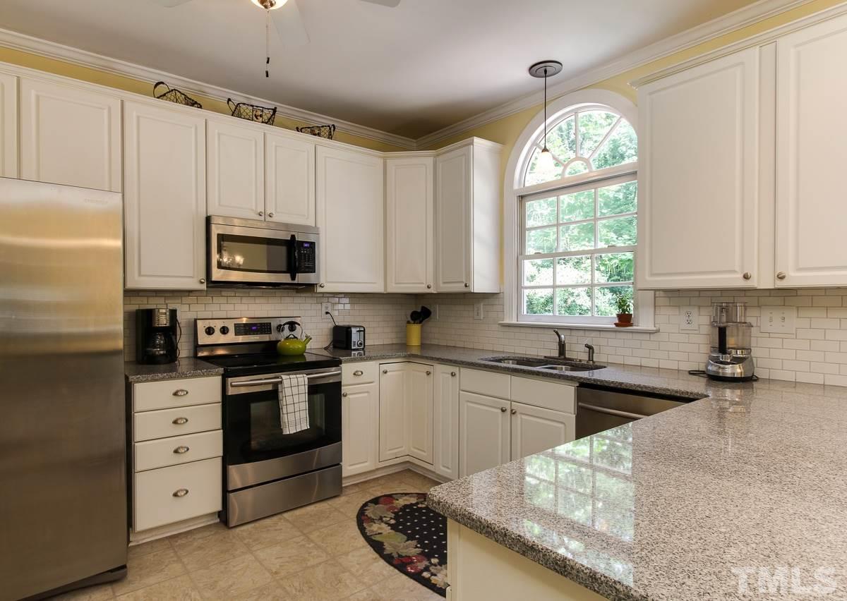 4601 Wee Burn Trail Raleigh, NC 27612 - Photo 8 of 25 a kitchen with stainless steel appliances granite countertop a sink a stove a microwave a refrigerator and cabinets