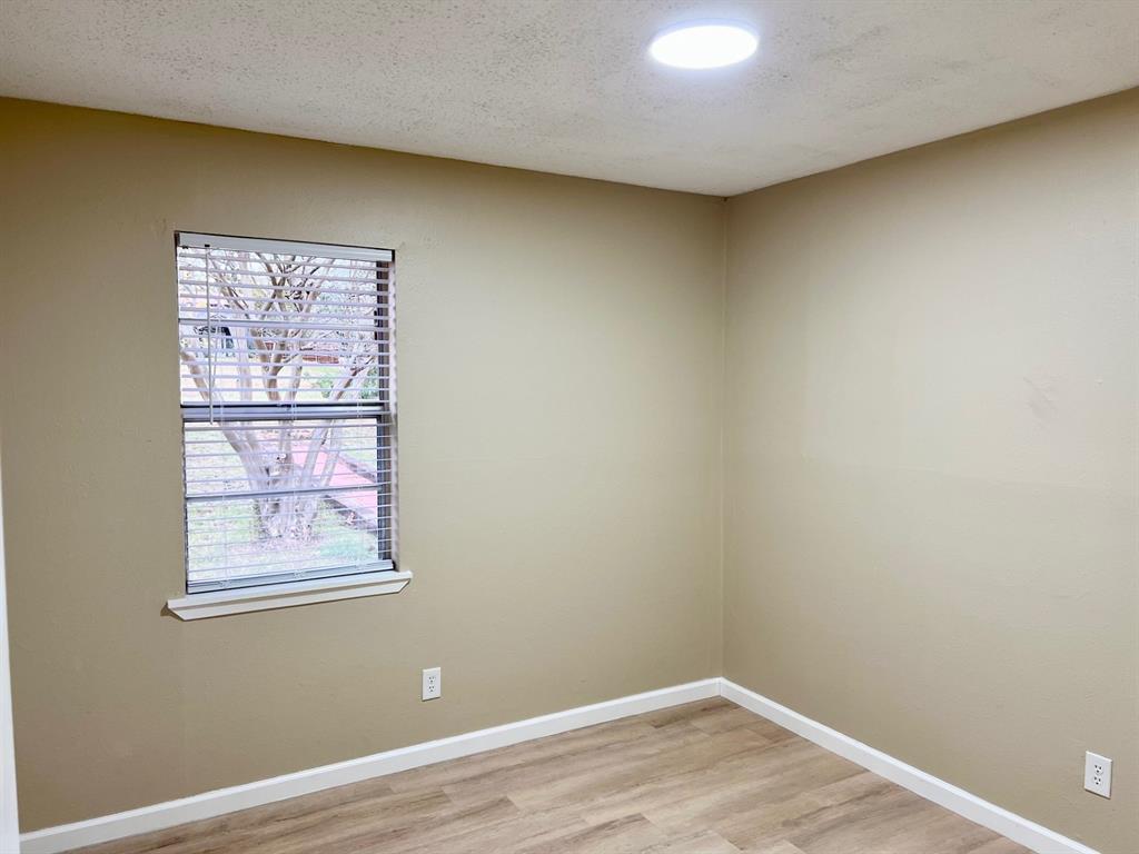 38 Valley View Circle Denison, TX 75021 - Photo 10 of 15 a view of an empty room with a window and wooden floor