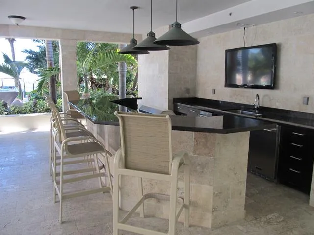 a kitchen with a sink and a flat screen tv