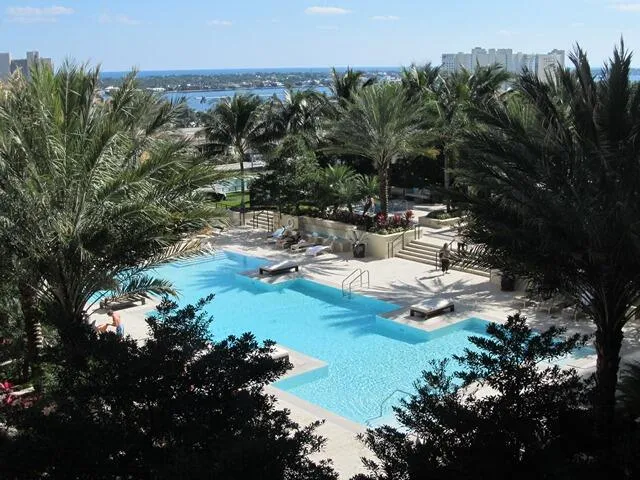 a view of a swimming pool with lawn chairs under an umbrella