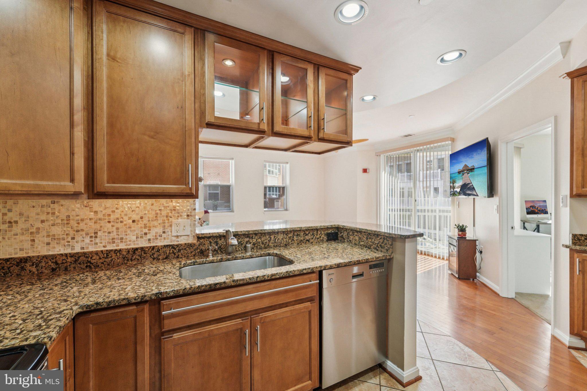 23 Pierside Drive, Unit 118 Baltimore, MD 21230 - Photo 12 of 32 a bathroom with a granite countertop sink and a mirror