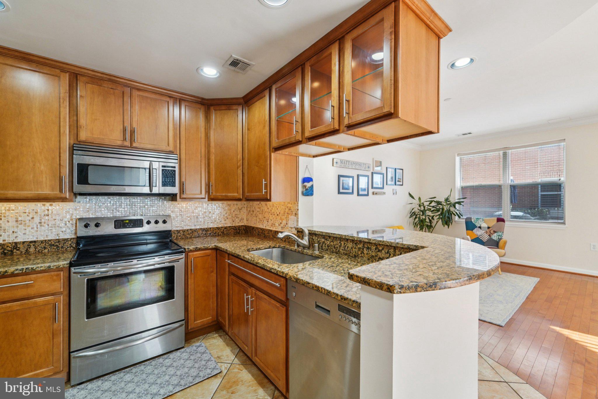 23 Pierside Drive, Unit 118 Baltimore, MD 21230 - Photo 14 of 32 a kitchen with stainless steel appliances granite countertop a stove a sink and a microwave