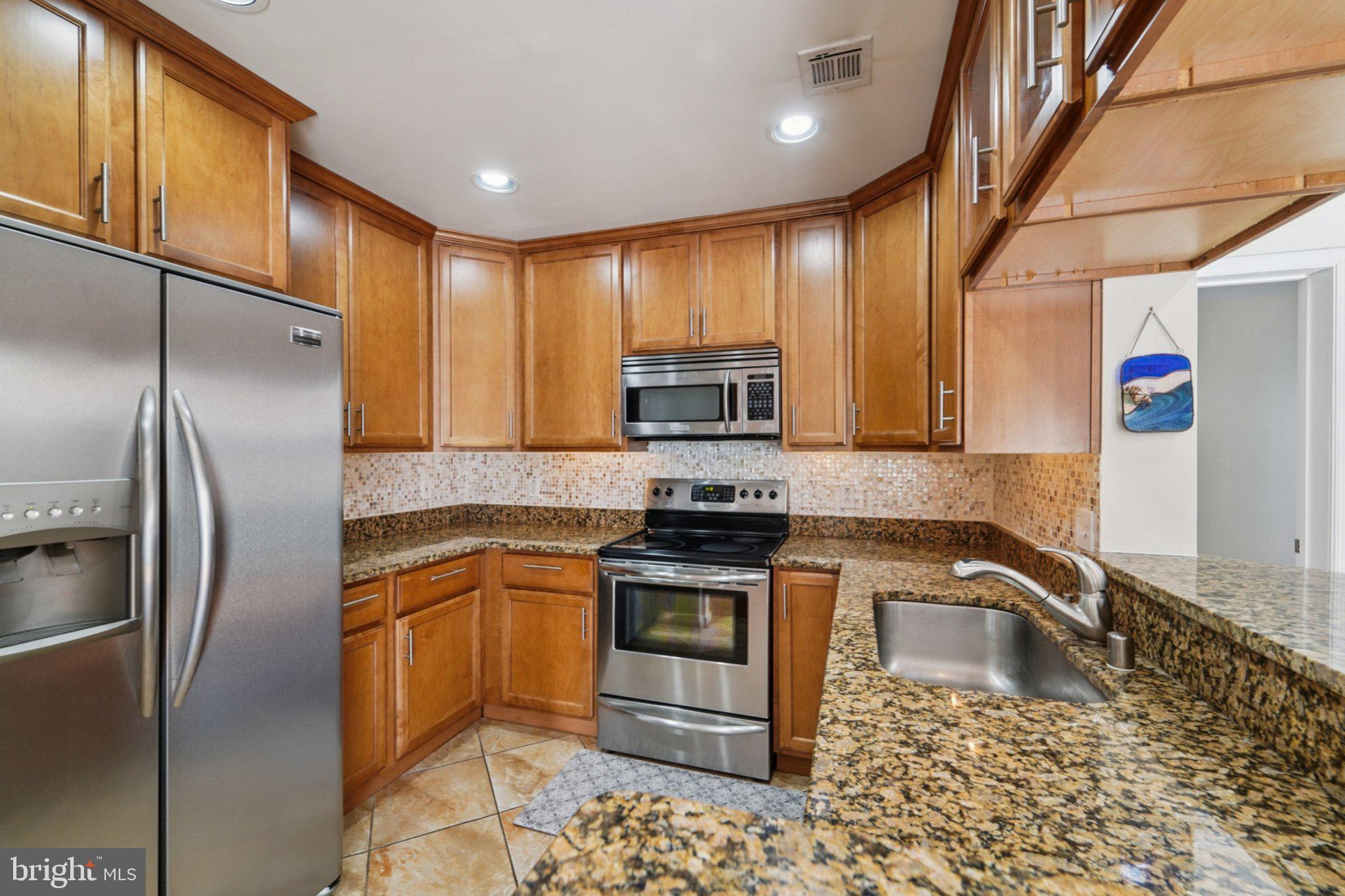 23 Pierside Drive, Unit 118 Baltimore, MD 21230 - Photo 15 of 32 a kitchen with granite countertop a sink stainless steel appliances and cabinets