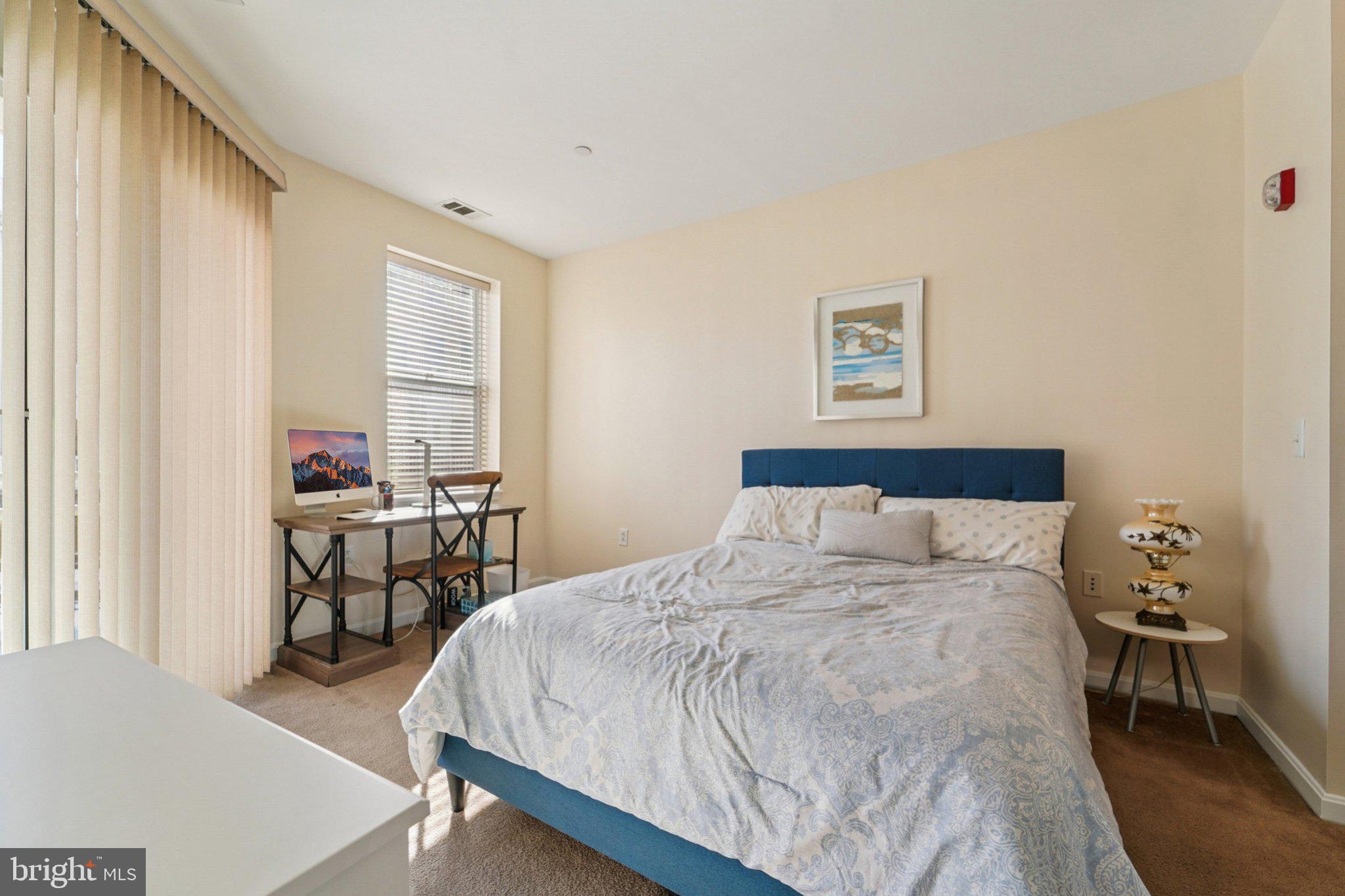 23 Pierside Drive, Unit 118 Baltimore, MD 21230 - Photo 18 of 32 a bedroom with a bed and a table in it