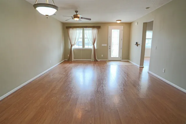 an empty room with wooden floor and a window