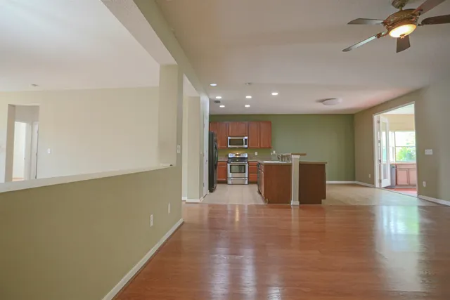 a view of kitchen with kitchen island a sink wooden floor and a counter top space