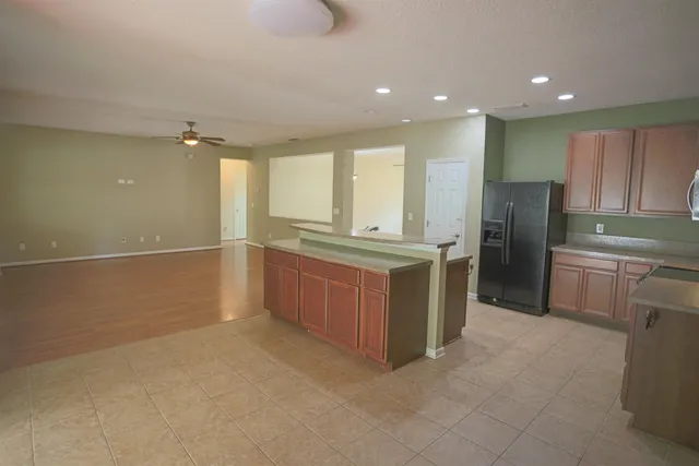a large kitchen with a large counter top and stainless steel appliances