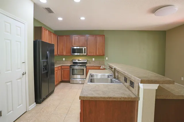 a kitchen with stainless steel appliances granite countertop a sink refrigerator and microwave