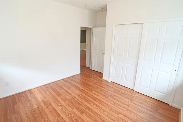a view of an empty room with wooden floor