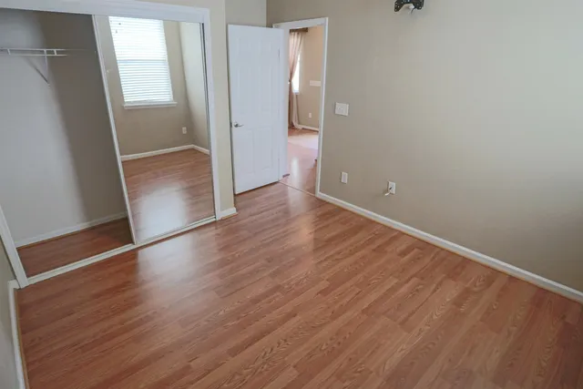 an empty room with wooden floor and entrance